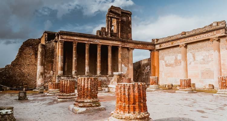 Ruines de Pompéi sous un ciel dramatique.