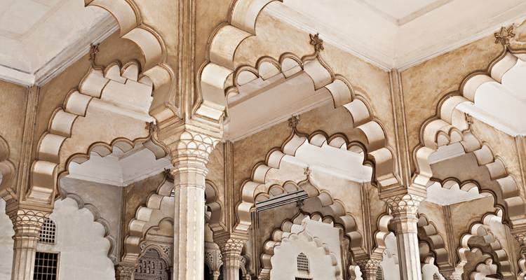 Arcos y columnas ornamentados dentro de un palacio histórico con diseños intrincados