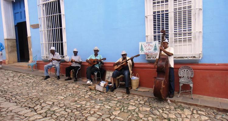 Group of street musicians playing in front of a colorful building.