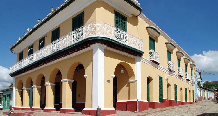 Colonial-style building with arches and a blue sky background.
