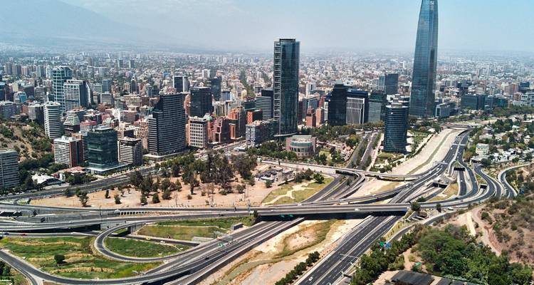 Paisaje urbano de Santiago con edificios modernos y autopistas.