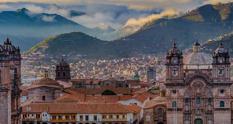 Panoramic view of a cityscape with historic buildings and mountains.