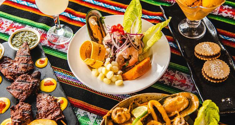 Variety of traditional dishes arranged on a colorful tablecloth.