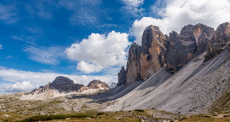 Sommets montagneux spectaculaires sous un ciel avec des nuages duveteux.