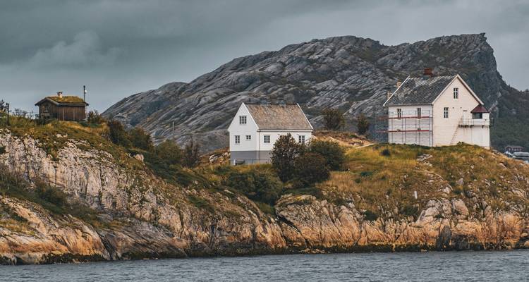 Kustlandschap met ruige rotsen en huizen.
