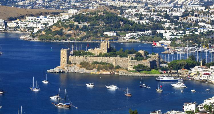Vista aérea del Castillo de Bodrum rodeado de aguas azules y pequeñas embarcaciones.