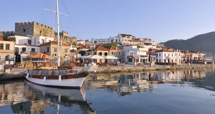 Marmaris waterkant met een aangemeerde boot en oude stadsgebouwen.
