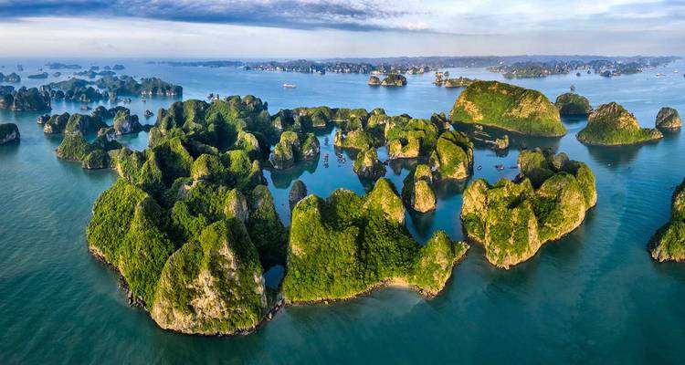 Panorama aéreo impresionante de islas de karst cubiertas de verde que se elevan desde aguas turquesas en la Bahía de Halong.