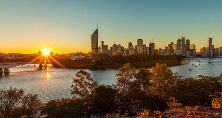 Coucher de soleil sur la rivière avec horizon urbain.