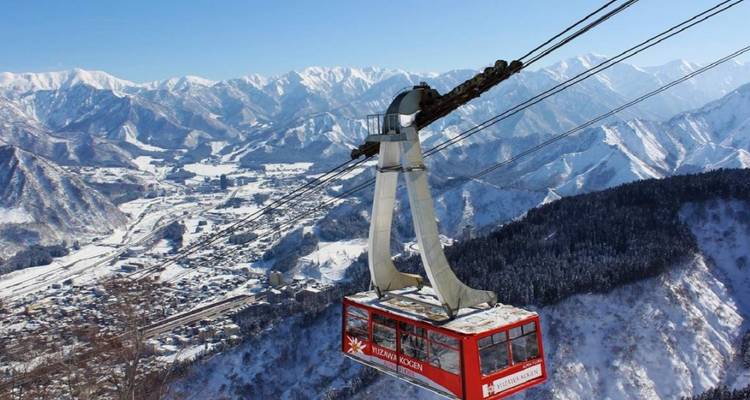 Téléphérique au-dessus de montagnes enneigées.