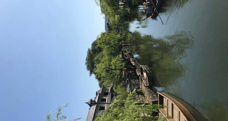 Canal paisible avec bateaux et arbres luxuriants.