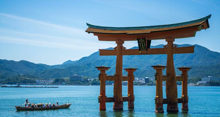 Torii iconique dans l'eau avec des touristes dans un bateau.