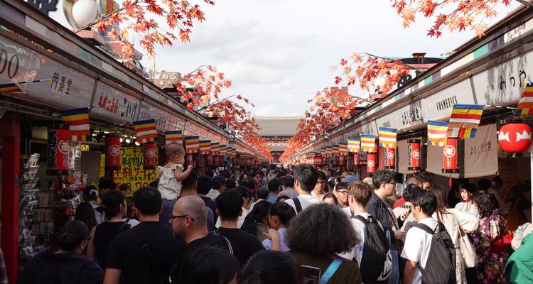 Rue de marché bondée avec des décorations colorées.