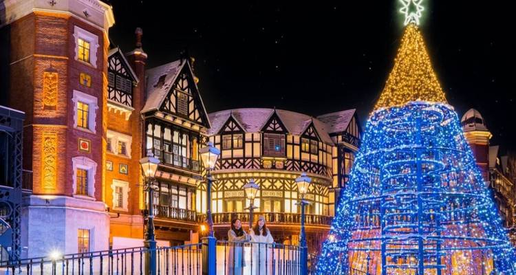 Illuminated Christmas decorations in a European style village setting at night.