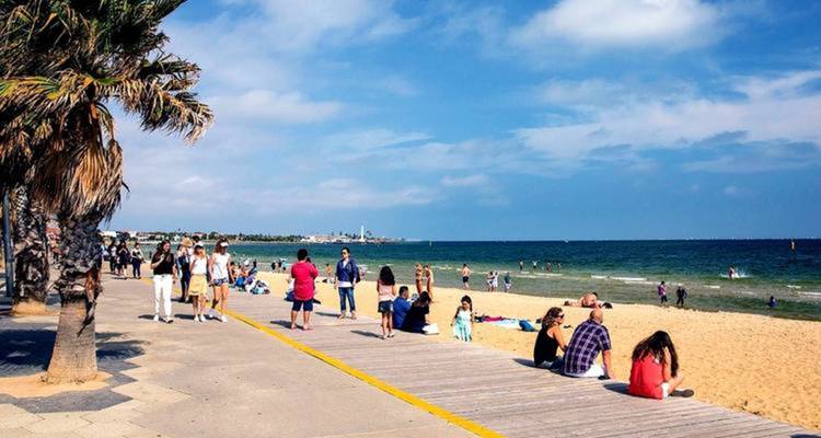 Promenade en bord de mer avec des gens profitant d'une journée ensoleillée au bord de la mer.
