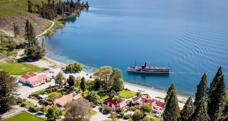 Aerial view of a lakeside resort area with a steamship on the lake.