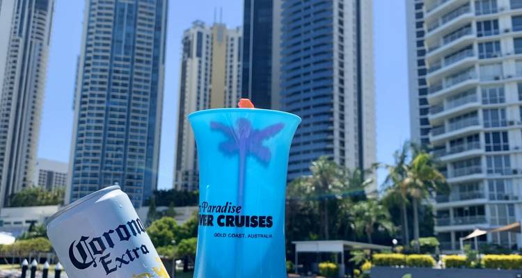 Persona sosteniendo una bebida frente a rascacielos.