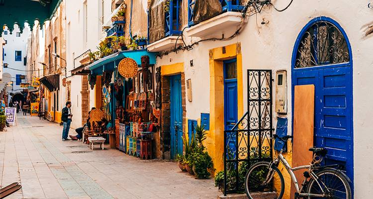 Street in a historic city with colorful doors and shops.