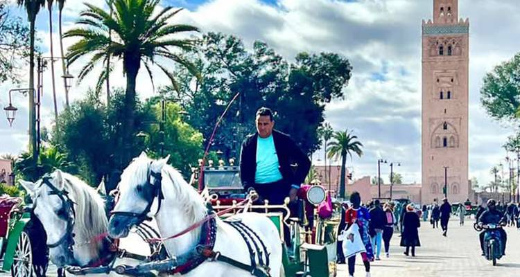 A man riding a horse-drawn carriage in a bustling square.