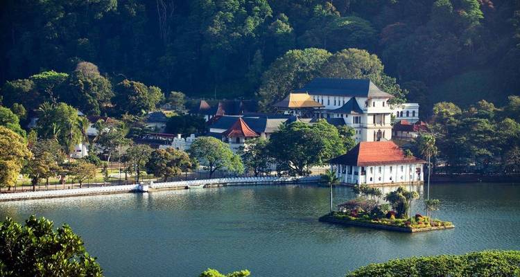 Scenic view of a lakeside temple complex surrounded by lush greenery.