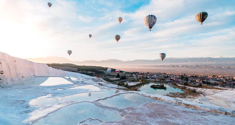 Globos aerostáticos sobre Pamukkale con terrazas de travertino.
