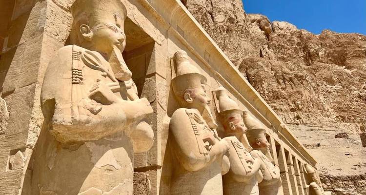Ancient statues carved into a rock face in Egypt.