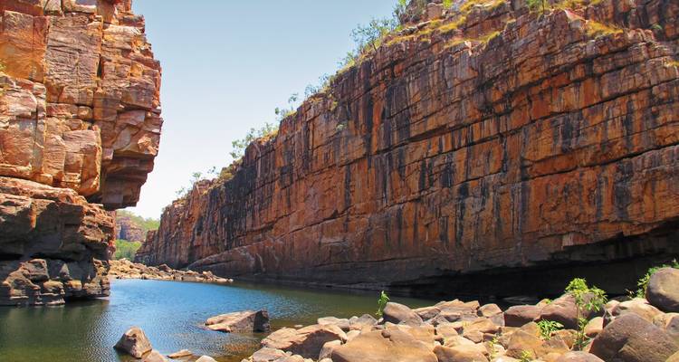 Rotsachtige kloof met helder water dat er doorheen stroomt.