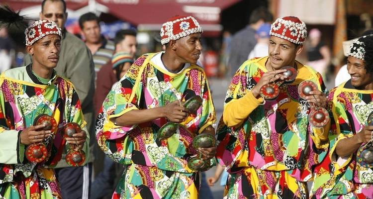 Un groupe de musiciens en tenue traditionnelle marocaine jouant des instruments.