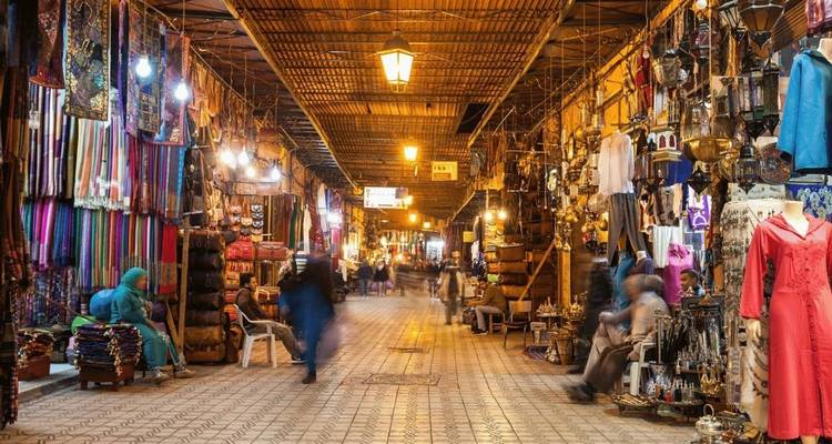 Un souk animé à Marrakech avec des textiles et de l'artisanat colorés.