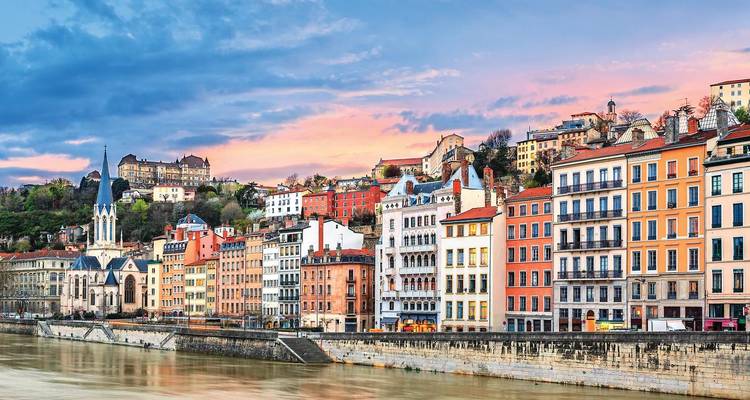 Les bâtiments colorés au bord du fleuve à Lyon au coucher du soleil.