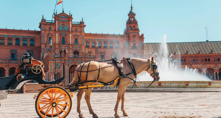 Horse-drawn carriage waits beside the ornate red-brick arches and fountain of Plaza de España.