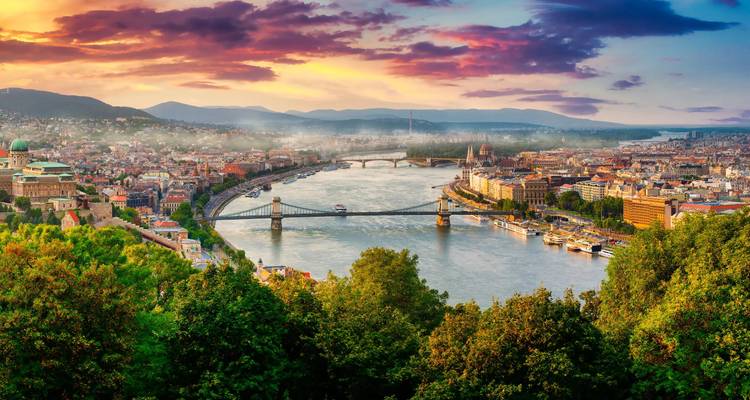 Les nuages pourpres de l'aube brillent au-dessus du Danube et de la ligne d'horizon de Budapest vus d'un point de vue élevé.