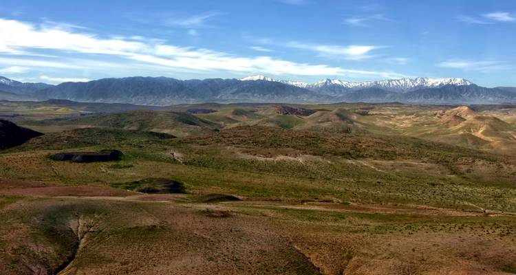 Vue panoramique d'un vaste paysage verdoyant avec des montagnes en arrière-plan.