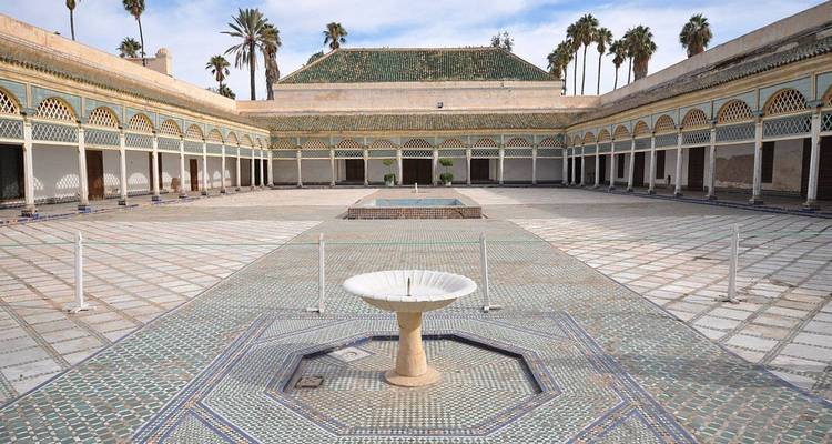 Cour spacieuse avec des carreaux de mosaïque complexes et une fontaine.