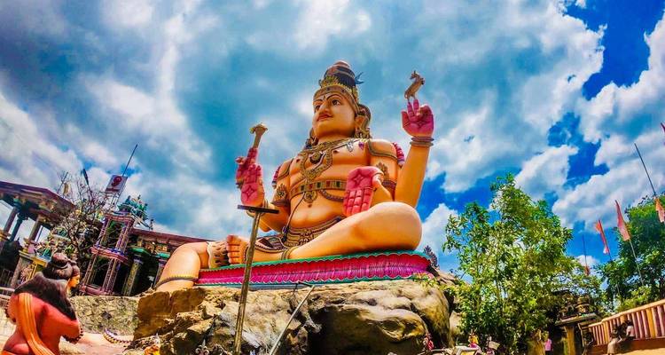 Grande statue colorée d'une divinité dans un cadre de temple.