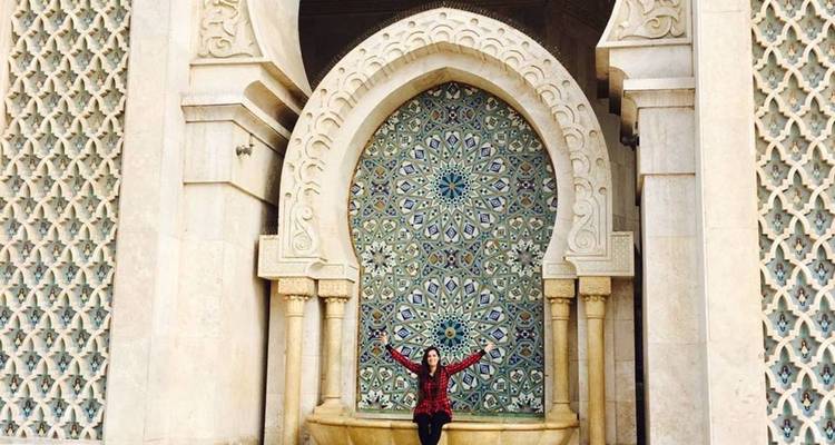 Personne assise devant une arche décorée avec des carreaux de mosaïque.