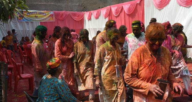 Group of people covered in colors celebrating Holi festival.