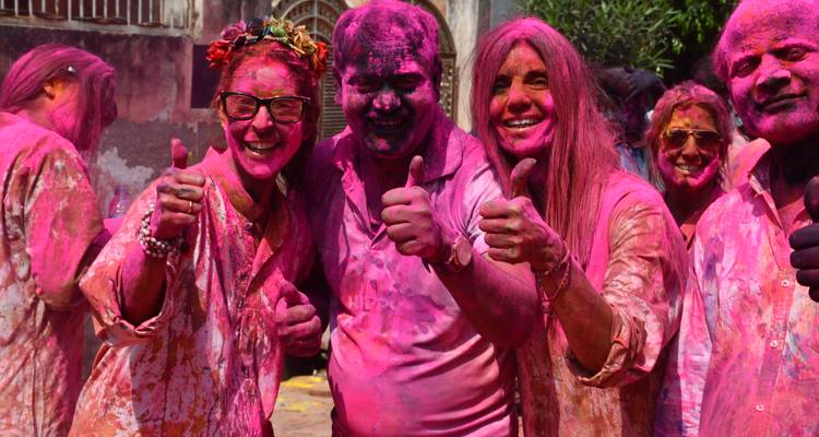 Group of friends giving thumbs up covered in Holi colors.