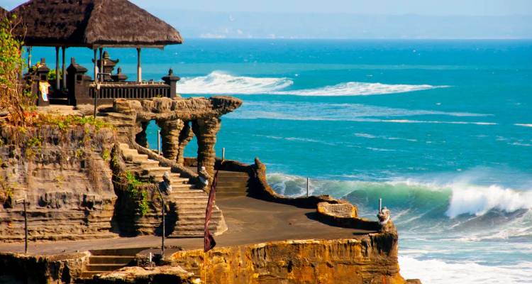 Oceaangolven die beuken tegen de Tanah Lot tempel op een rots.
