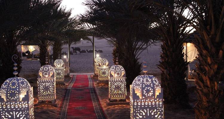 Lanternes décoratives éclairées dans un complexe touristique du désert au crépuscule.