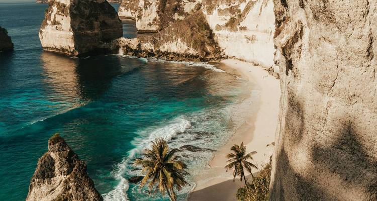 Plage isolée avec des eaux turquoise claires et des falaises rocheuses.