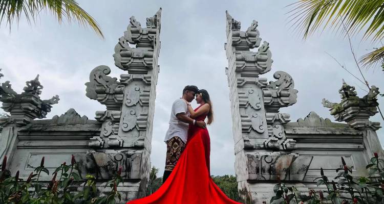 Couple se tenant romantiquement devant des portes traditionnelles.