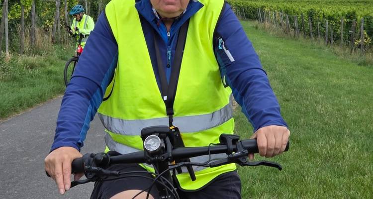 Cycliste portant un gilet réfléchissant sur une piste cyclable.