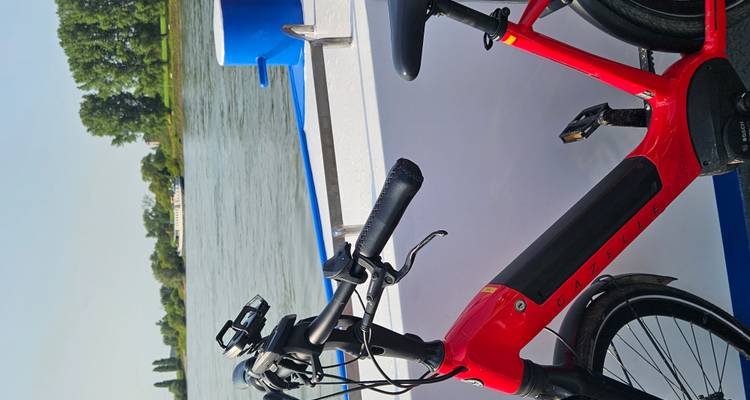 Vélo appuyé contre un ferry sur une rivière.