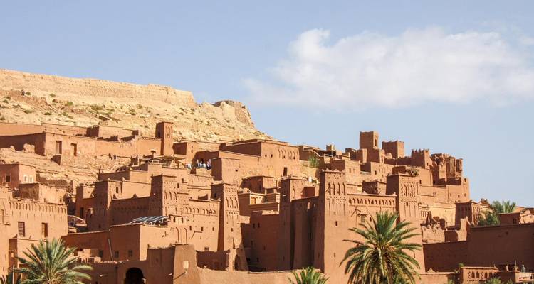 Vue panoramique du village fortifié en terre crue d'Aït Benhaddou sur un ciel dégagé.