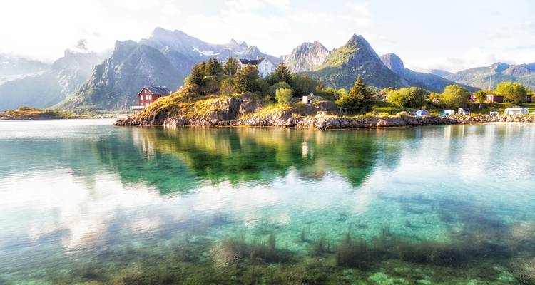 Scenic coastal village with clear water and mountains.