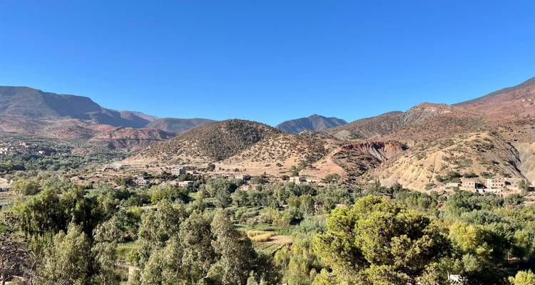 Landscape view of mountains and greenery under a clear blue sky.