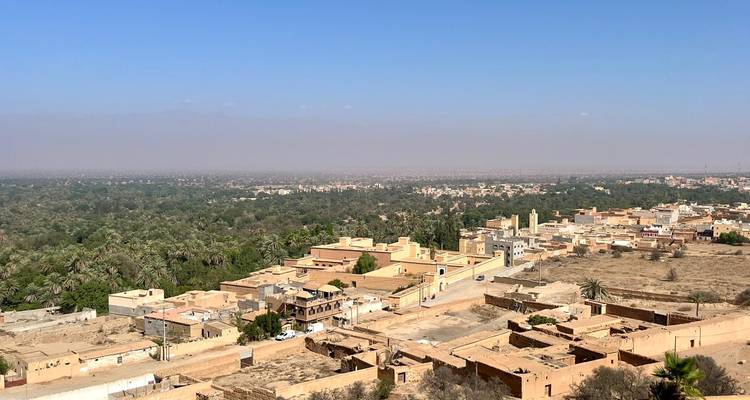 View of a town in a desert landscape with sparse vegetation.