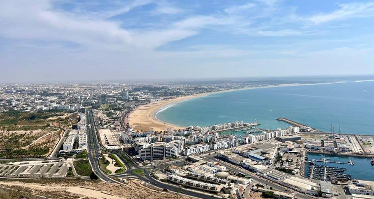 Aerial view of a coastal city with a promenade and harbor.