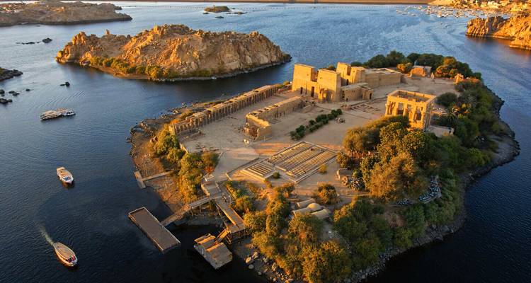 Vue aérienne spectaculaire du complexe du temple de Philae situé sur une île et entouré par les eaux du Nil au coucher du soleil